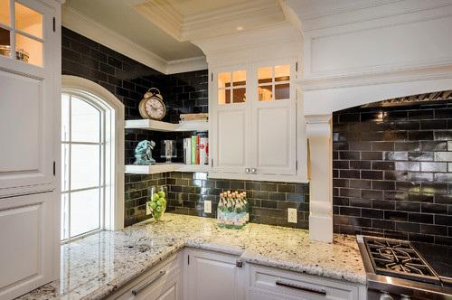 Black Subway Ceramic Backsplash with Colonial White Granite Countertop and White Glass Door Inside Lighting Cabinets